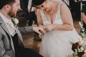 Bride putting wedding ring on grooms finger