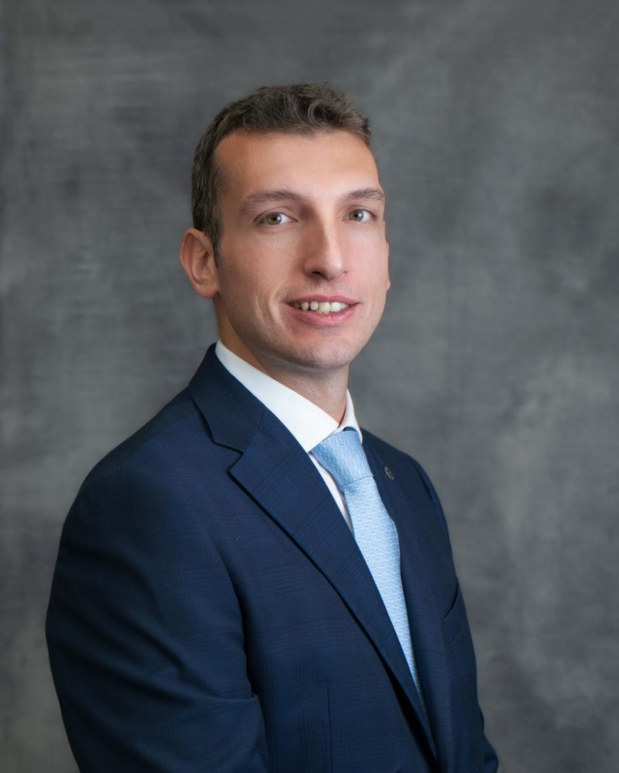 Corporate headshot of a man in a navy suit