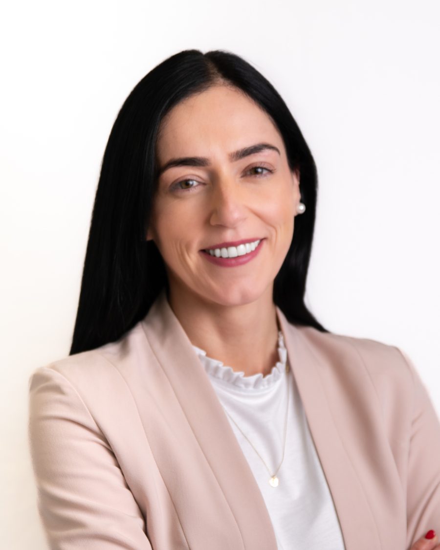 Headshot of a woman in a blush pink blazer on a bright white background