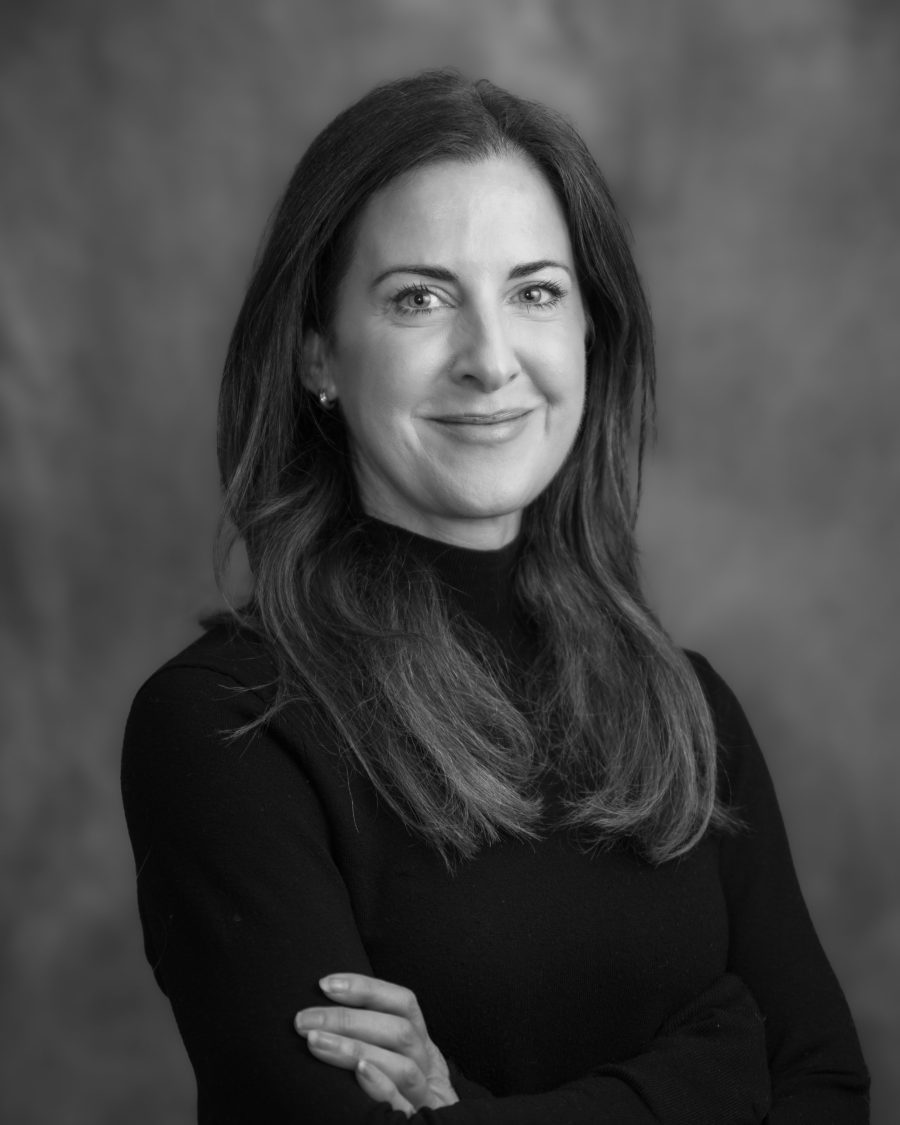 Black and white business portrait of a woman with arms folded