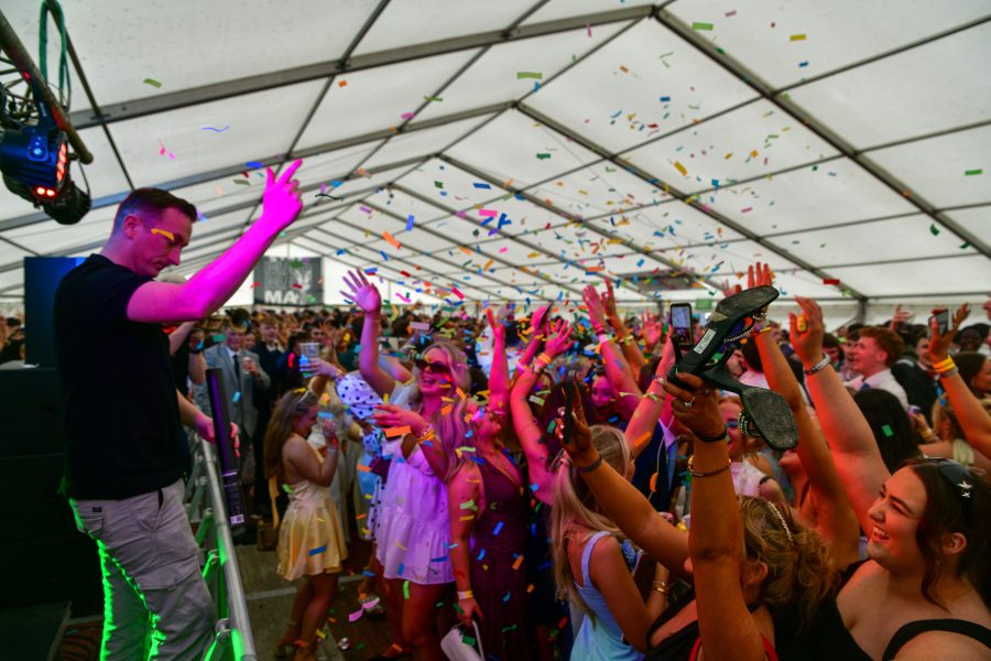 A packed marquee celebrating at a race day