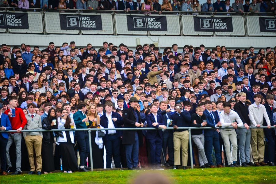 Packed stand of racegoers watching a race