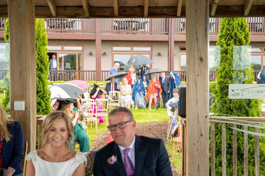 Guests keeping dry during a wedding ceremony